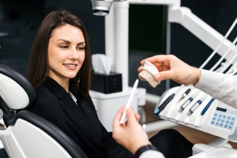 Dentist showing patient a dental model.